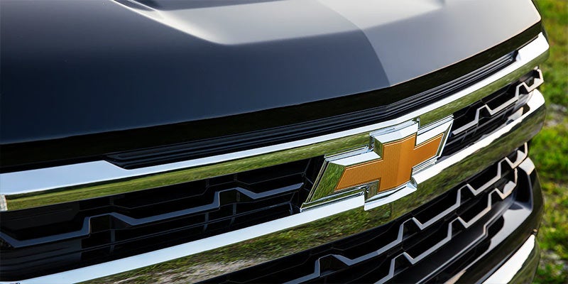 Front grille of a black Chevrolet truck showcasing its bold design.