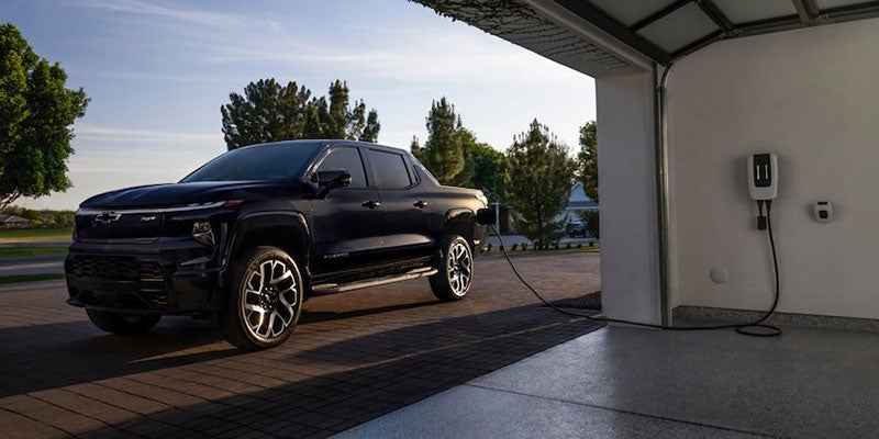 A 2021 Chevrolet Silverado electric truck is connected to a charging station